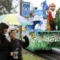 Carnival revelers wave to passing floats near the start of the Krewe of Endymion parade, which was postponed for an hour because of heavy rain, in New Orleans on Saturday, Feb. 18, 2012. (AP Photo/Jonathan Bachman)