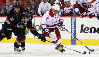 Washington Capitals&#x27; Alex Ovechkin has the puck poked away by Carolina Hurricanes&#x27; Brandon Sutter (16) with Hurricanes&#x27; Tim Gleason nearby, during the first period in Raleigh, N.C., Monday, Feb. 20, 2012. (AP Photo/Karl B DeBlaker)
