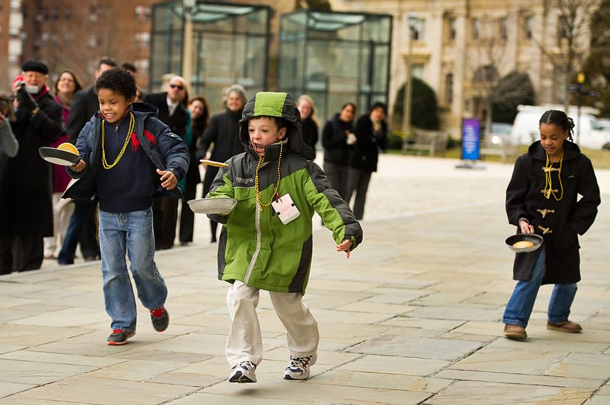 Left to right: Beauvoir National Cathedral Elementary School second graders Earle Horton, Philip Sears, and Honor Johnson participate in the Washington National Cathedral Pancake Races held in front of the Cathedral on Shrove Tuesday, more commonly known as "Mardi Gras.", Washington, D.C., Tuesday, Feb. 21, 2012. This years annual Pancake Races are entitled the “Shake, Rattle & Race Edition,†in light of the earthquake damage the cathedral sustained earlier this year. (Andrew Harnik/The Washington Times)