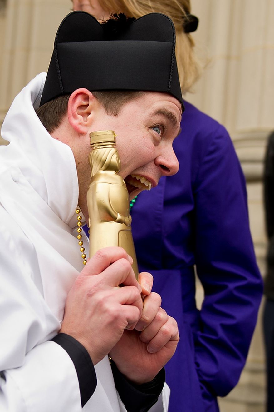 Assistant Rector for St. Alban's Parish Reverend Matthew Hanisian proudly shows off his "Golden Mrs. Butterworth" syrup bottle after winning his race at the Washington National Cathedral Pancake Races held in front of the Cathedral on Shrove Tuesday, more commonly known as "Mardi Gras.", Washington, D.C., Tuesday, Feb. 21, 2012. This years annual Pancake Races are entitled the “Shake, Rattle & Race Edition,†in light of the earthquake damage the cathedral sustained earlier this year. (Andrew Harnik/The Washington Times)
