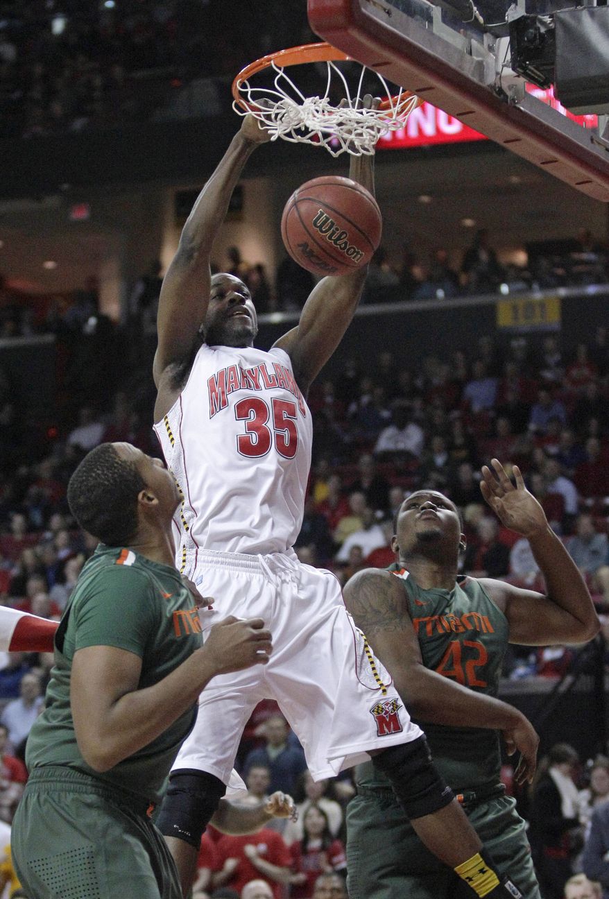 Maryland forward James Padgett dunks on Miami's Kenny Kadji, left, and Reggie Johnson in College Park, Md., Tuesday, Feb. 21, 2012. (AP Photo/Patrick Semansky)