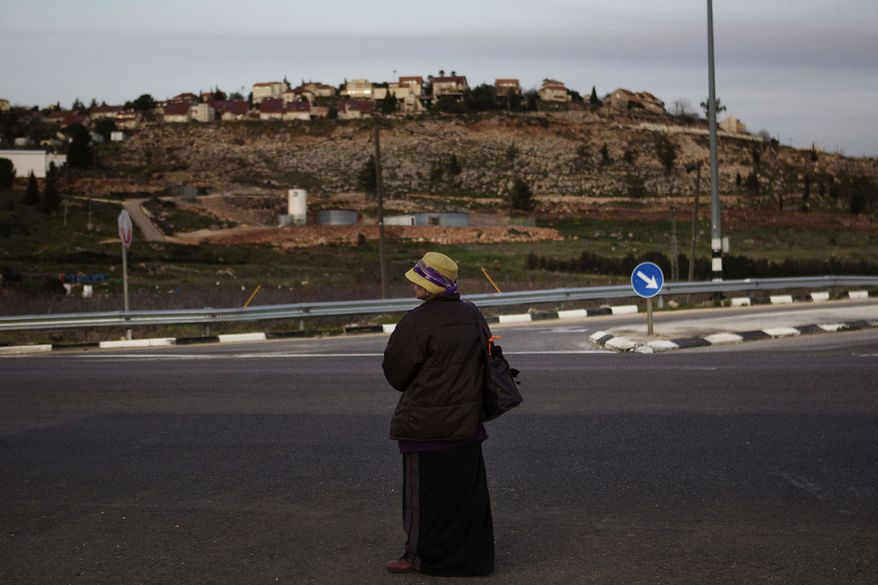 A Jewish settler woman waits Feb. 22, 2012, for a ride outside the Jewish West Bank settlement of Shilo. Israel gave preliminary approval to a plan to build 600 new homes in a settlement deep inside the West Bank, a move that drew a rebuke from the United Nations and Palestinians and threatened to raise new tensions with the U.S. as the prime minister prepares to head to the White House. (Associated Press)