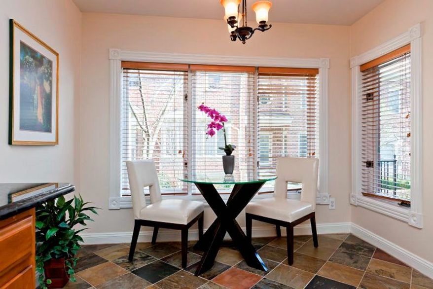 The breakfast area adjacent to the kitchen shares the same flooring. It has a triple window facing the courtyard as well as a side window.
