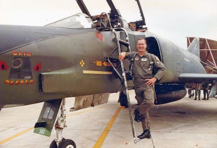 Air Force Lt. Col. Mike Ross stands beside a reconnaissance aircraft similar to the one he was flying in a 1987 training mission when he was shot down by a Navy pilot and had to eject.