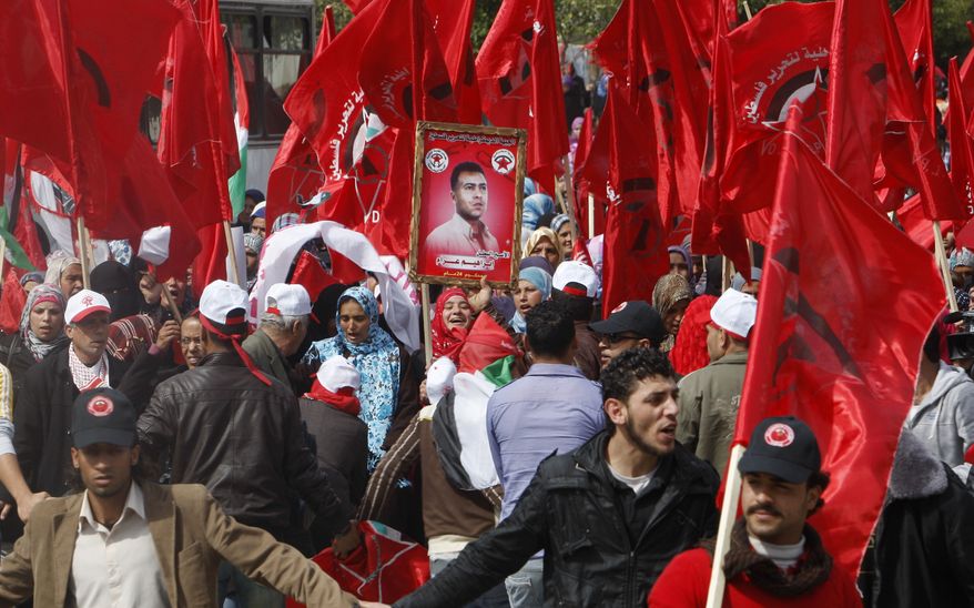 Palestinian supporters of the Democratic Front for the Liberation of Palestine wave their party's red flags during a Feb. 23, 2012, rally in Gaza City celebrating 43 years since its founding. (Associated Press)