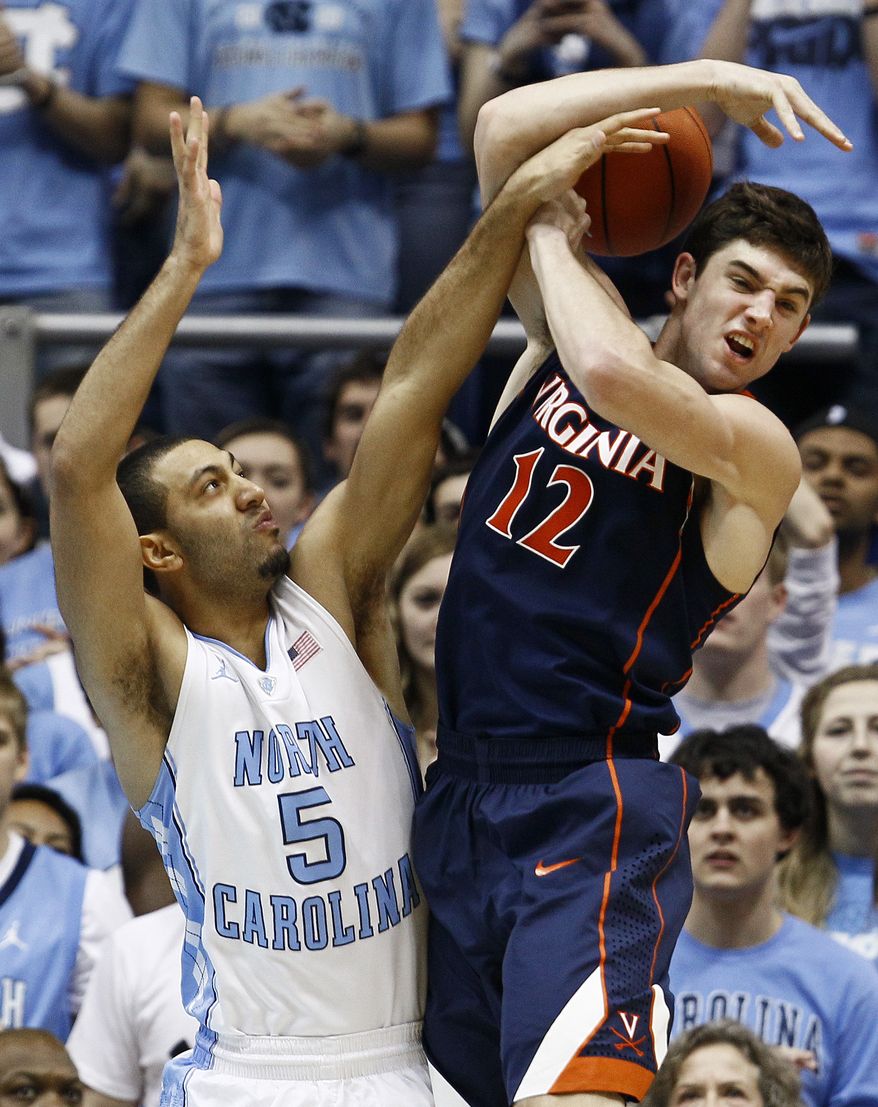 North Carolina's Kendall Marshall and Virginia's Joe Harris struggle for a rebound during the first half in Chapel Hill, N.C., Saturday, Feb. 11, 2012. Virginia lost 70-52. (AP Photo/Gerry Broome)
