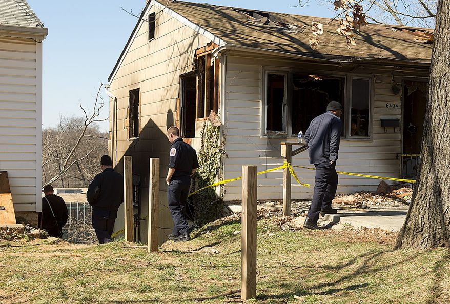 Firefighters with the Landover Hills Fire Department check out a fire-damaged house from a February 2012 arson in Riverdale, where two firefighters with the Bladensburg Volunteer Fire Department suffered serious burns. (Barbara L. Salisbury/The Washington Times)