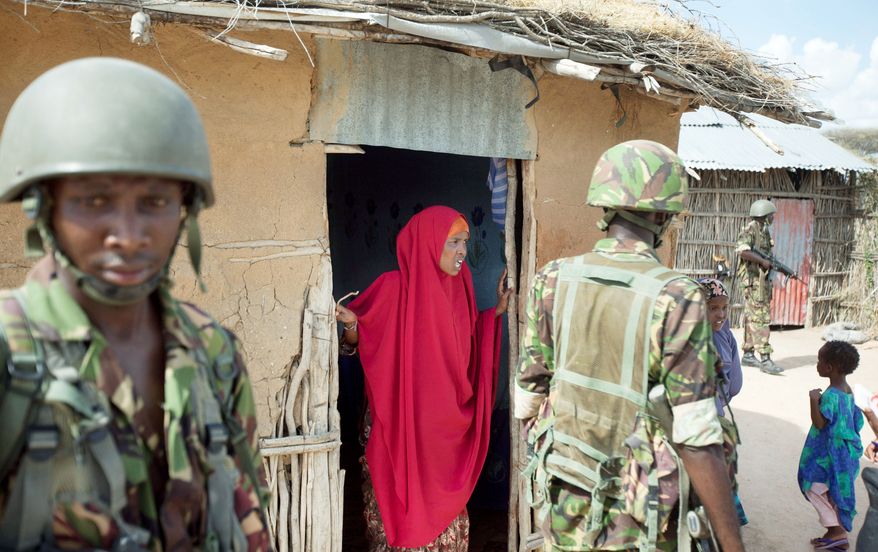 A Somali villager talks to Kenyan soldiers, who crossed the border after abductions and grenade attacks inside Kenya were linked to the al Qaeda-linked al-Shabab in Somalia. (Associated Press)