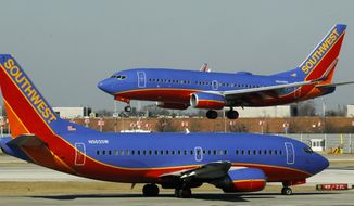 A Southwest Airlines Boeing 737 waits to take off from Chicago&#39;s Midway International Airport as another lands on Thursday, Feb. 9, 2012. (AP Photo/Charles Rex Arbogast)