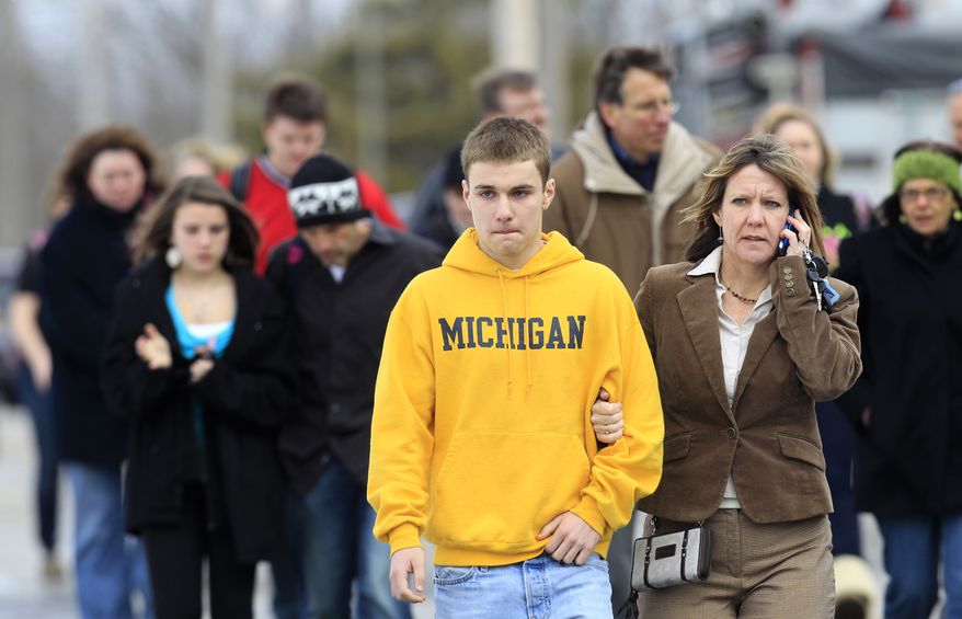 Students leave with their parents from Maple Elementary School after a shooting at Chardon High School on Monday, Feb. 27, 2012, in Chardon, Ohio. A suspect is in custody. (AP Photo/Tony Dejak)