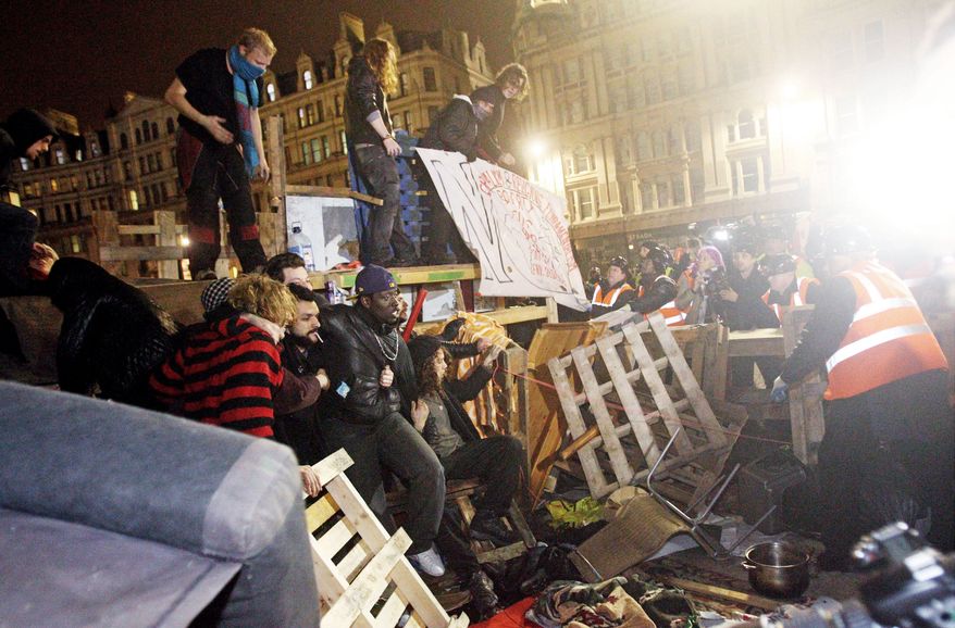 Demonstrators resist an effort by police to clear out the Occupy London camp outside St. Paul's Cathedral on Tuesday. The police removed tents from the anti-capitalist protest camp in London. The High Court ruled that the eviction of the Occupy London protest camp could proceed. (Associated Press)