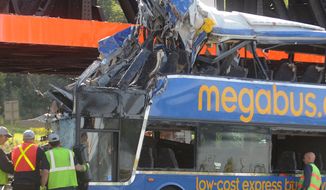 **FILE** Investigators examine the driver&#39;s area of the bus at the scene of a fatal double-decker Megabus accident just outside Syracuse, N.Y., on Sept. 11, 2010. The bus hit the Onondaga Lake Parkway railroad bridge abutment and rolled onto its side, killing four passengers. (Associated Press/The Post-Standard)