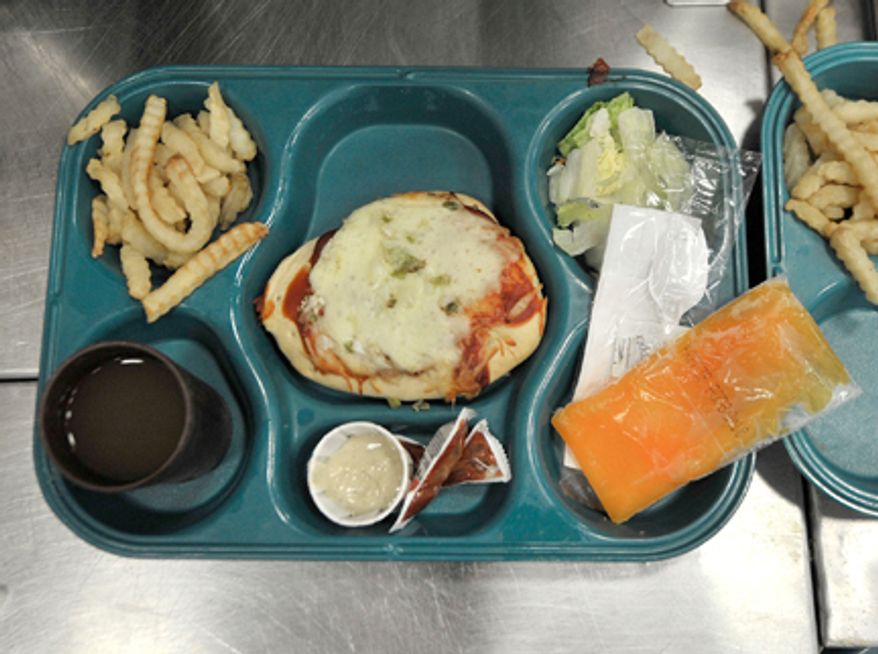 **FILE** A tray containing pizza, fries, salad, a frozen fruit desert and drink is prepared July 21, 2011, for a prisoner during lunch at the Bellamy Creek correctional facility near Ionia, Mich. (Associated Press/The Detroit News)