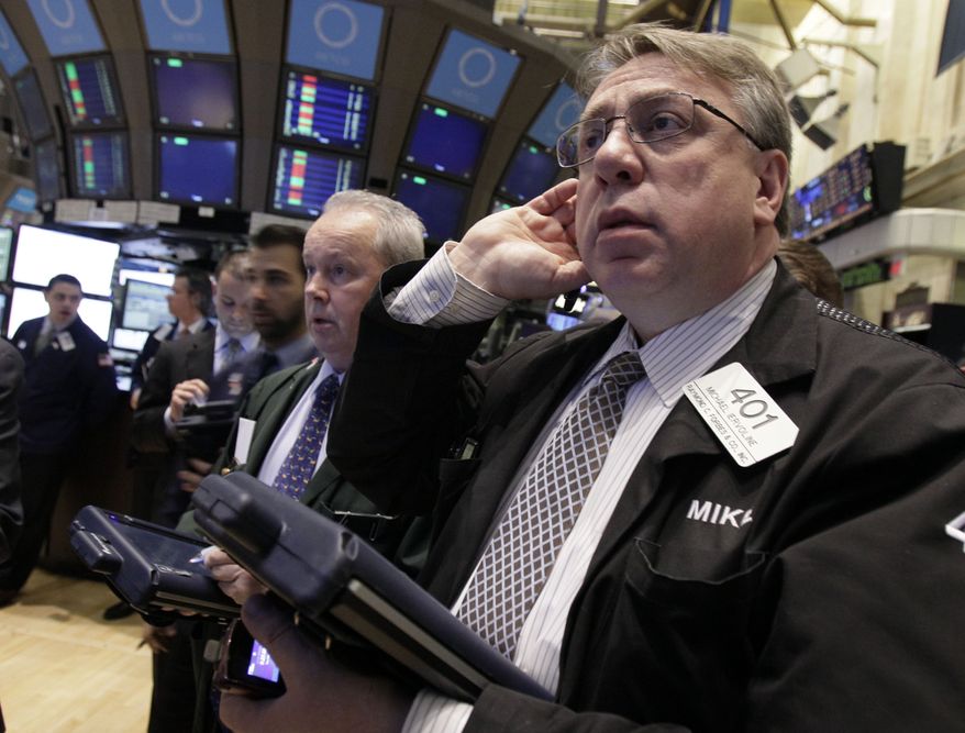 Trader Michael Iervoline (right) works on the floor of the New York Stock Exchange on Feb. 28, 2012. (Associated Press)