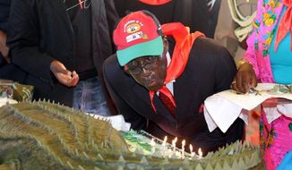 Zimbabwean President Robert Mugabe blows out the candles on his birthday cake as he turns 88. The cake was baked in Harare and transported to Mutare under police escort for an annual celebration targeted at Zimbabwean youths. (Associated Press)