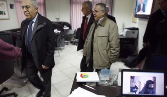 Palestinian Prime Minister Salam Fayyad (left) visits the offices of al-Watan TV after an Israeli army pre-dawn raid in the West Bank city of Ramallah on Feb. 29, 2012. A Palestinian broadcaster says Israeli troops raided his TV station, seizing transmission equipment, computers and documents. A computer screen on right shows an Israeli soldier during the raid. (Associated Press)