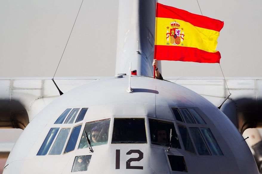 A Spanish flag is waved from a plane carrying some of the 17 tons of silver and gold coins scooped up from a Spanish warship, Nuestra Senora de las Mercedes, that sank during a 1804 gunbattle, after its arrival at the Torrejon De Ardoz military air base, near Madrid, on Saturday Feb. 25, 2012. (AP Photo/Daniel Ochoa de Olza)