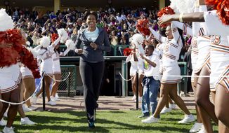 ** FILE ** First lady Michelle Obama runs onto the field as she arrives for physical activity with kids at the ESPN Wide World of Sports Complex at the Walt Disney World Resort in Orlando, Fla., on Saturday, Feb. 11, 2012 during her three-day national tour celebrating the second anniversary of the &quot;Let&#39;s Move&quot; program fighting childhood obesity. (AP Photo/Carolyn Kaster)