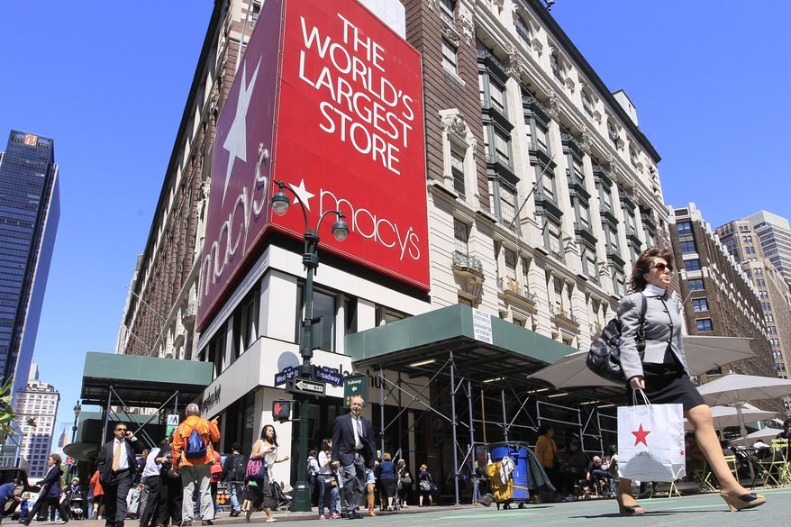 ** FILE ** Shoppers carrying Macy's bags walk past the chain's flagship store in New York in May 2011. (AP Photo/Mary Altaffer, File)