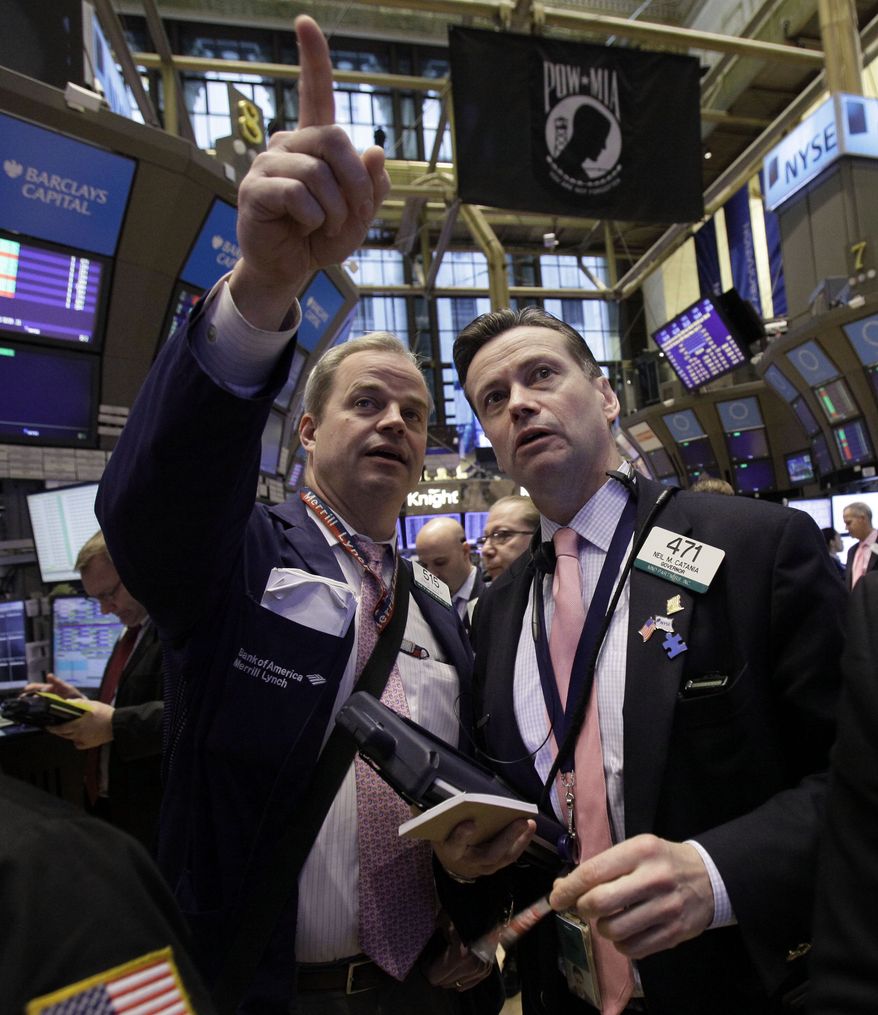 Traders David O'Day (left) and Neil Catania confer on the floor of the New York Stock Exchange on March 2, 2012. (Associated Press)