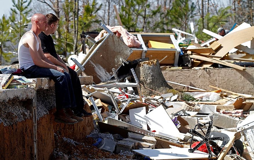 Steven Skaggs, front, and Mike Hatheway sit on a foundation of their grandparents home where a deadly tornado destroyed houses in the Rinnie Community near Crossville, Tenn. Thursday, March 1, 2012. Their grandmother Carolyn Jones was killed and his grandfather Harold Jones was taken to the hospital. (AP Photo/Wade Payne)