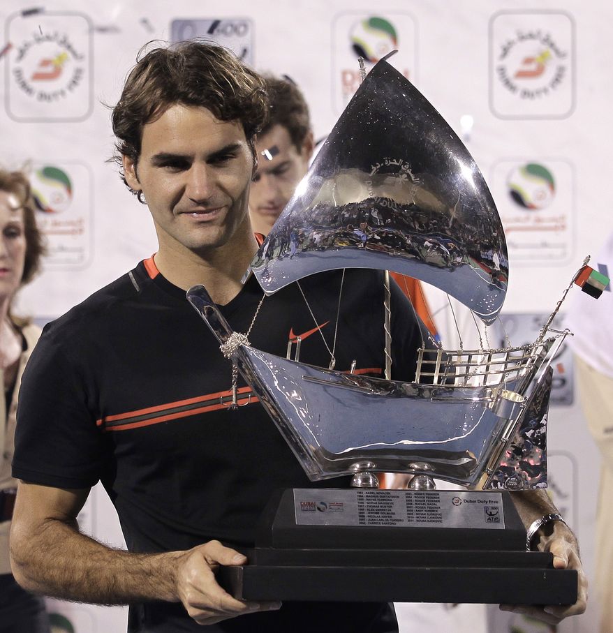 Roger Federer holds the winning trophy after defeating Andy Murray in the men's singles final at the Emirates Dubai ATP Tennis Championships in Dubai, United Arab Emirates, on Saturday, March 3, 2012. (AP Photo/Hassan Ammar)