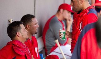 Nationals catcher Jhonatan Solano (left) shares strategy with catcher Sandy Leon (right) during an exhibition Friday at Space Coast Stadium in Viera, Fla. Both are behind Wilson Ramos and Jesus Flores on Washington&#39;s depth chart. (Andrew Harnik/The Washington Times)