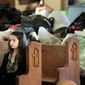 A girl attending mass at St. Francis Xavier Catholic Church sits in a pew in front of clothing and supplies that have been collected to aid victims of a tornado in Henryville, Ind., Sunday, March 4, 2012. The church was in the path of a tornado that destroyed much of the town. Three people were killed in Southern Indiana by Tornados on Friday. (AP Photo/Michael Conroy)
