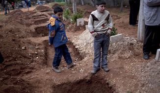 Children attend the funeral of three Free Syrian Army fighters on Saturday, March 3, 2012, in a park converted to a cemetery in Idlib, Syria. (AP Photo/Rodrigo Abd)