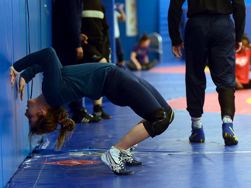 Helen Maroulis, a wrestler from Rockville, Md, may be the best U.S. wrestler in her weight class. She is currently training at the U.S. Olympic Training Center in Colorado Springs, Colo. She and other members of the U.S. team, as well as wrestlers from other countries, spent time training together, Thursday,Mar. 1, 2012. She stretches before the start of an light work out. (BryanOller/Special to the Washington Times)