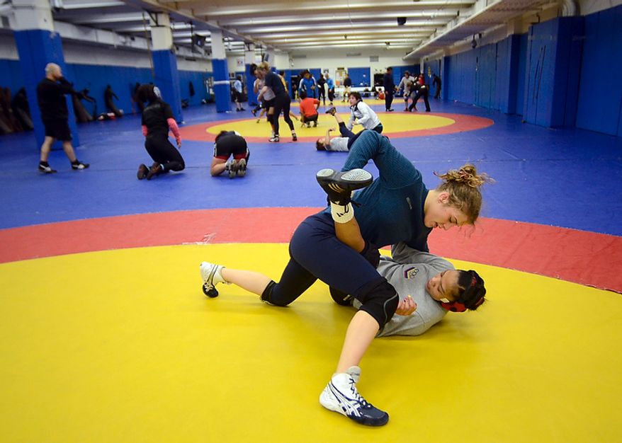 Helen Maroulis, a wrestler from Rockville, Md, may be the best U.S. wrestler in her weight class. She is currently training at the U.S. Olympic Training Center in Colorado Springs, Colo. She and other members of the U.S. team, as well as wrestlers from other countries, spent time training together, Thursday,Mar. 1, 2012. Maroulis and Venezuelan wrestler Marcia Andrades practice a two-arms one leg professional wrestling move. (BryanOller/Special to the Washington Times)