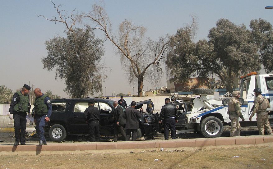 Iraqi security forces inspect the scene of a car bomb attack in the Mansour neighborhood of Baghdad on Wednesday, March 7, 2012. (AP Photo/Khalid Mohammed)