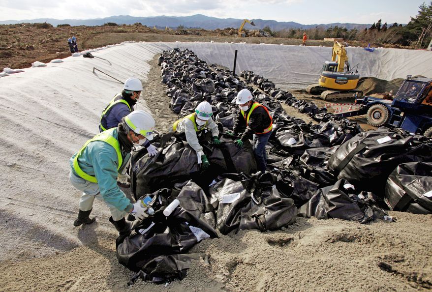 Workers dump bags filled with radiation contaminated soil - and sometimes the snow that had covered it - from a neighborhood in Hirono. "We often encounter situations that are not in the manual and wonder if we are doing the right thing," worker Takahiro Watanabe said.