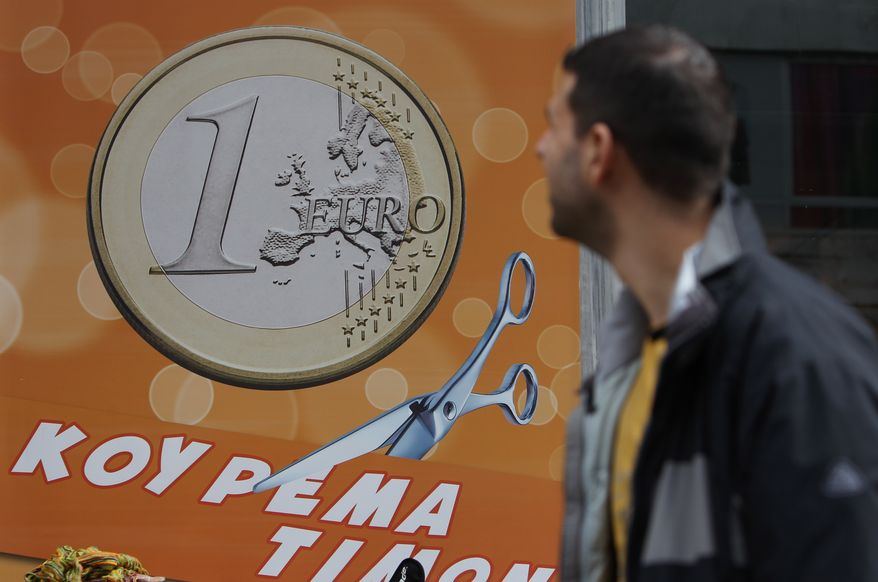 A pedestrian looks a shop sign that reads, ''One euro, price haircut,'' in Athens on Thursday, March 8, 2012. (AP Photo/Thanassis Stavrakis)