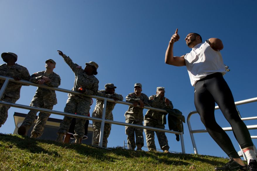 Retired Staff Sgt. Mike Kacer, right, of Scranton Pa. who lost his arm in a rocket explosion in Afghanistan on June 18, 2008 jokes with a Cadre of soldiers with the Warrior Transition Unit while Kacer competes with other wounded soldiers and Army veterans from across the United States in the Army Warrior Games clinics for a chance at a spot on the Army Warrior Games team, Fort Meade, Md., Sunday, March 11, 2012. The 2012 Warrior Games, held April 30th - May 5th in Colorado Springs, Colo., features representatives from Army, Navy, Air Force, Marines and Special Operations and will compete for gold metals in archery, cycling, wheelchair basketball, shooting, swimming, track and field, and sitting volleyball. (Andrew Harnik/The Washington Times)