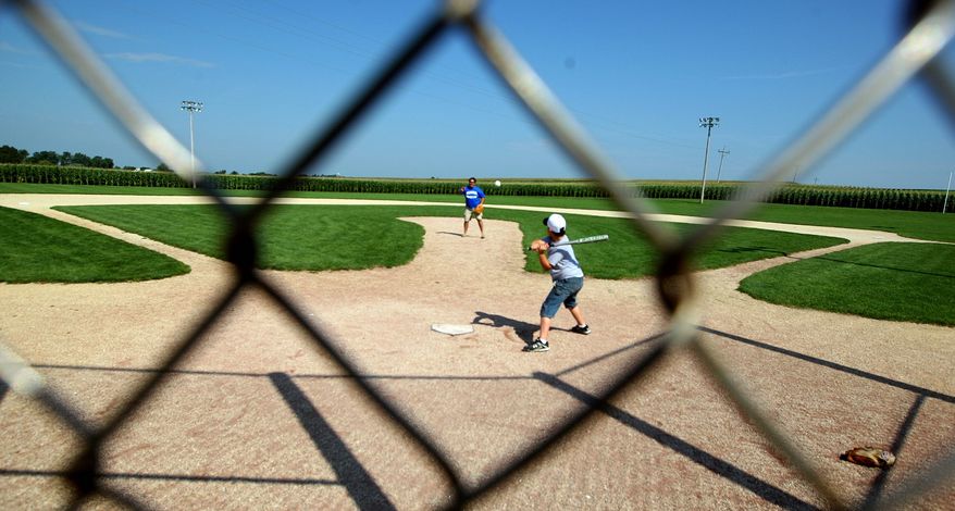 In this July 14, 2004, photo people enjoy the Field of Dreams baseball field in rural Dyersville, Iowa. The town is considering a $38 million plan to turn the farmland around the famous cornfield diamond into a marquee destination for traveling youth baseball teams. While the plan could provide an economic jolt to the region, it also has unleashed an emotional battle as the town of 4,000 tries to decide if they should build it. (AP Photo/Dubuque Telegraph Herald, Dave Kettering)