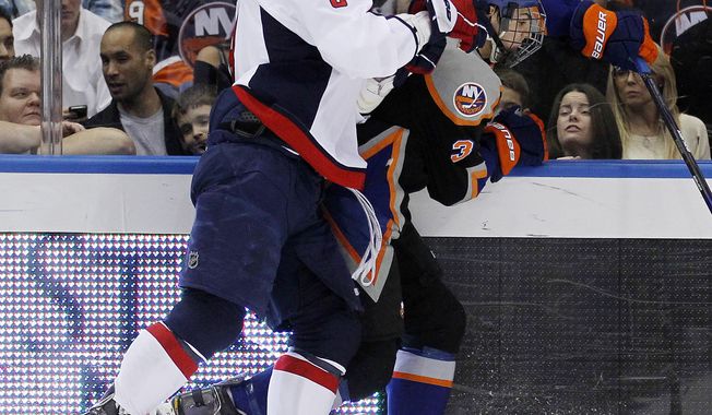 New York Islanders&#x27; Travis Hamonic (3) is checked by Washington Capitals&#x27; Alex Ovechkin during the first period of an NHL game in Uniondale, N.Y., Tuesday, March 13, 2012. The Capitals won 5-4 in a shootout. (AP Photo/Paul J. Bereswill)