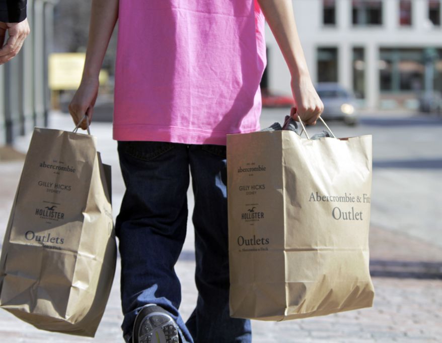 A shopper carries bags of merchandise in Freeport, Maine, on Monday, March 12, 2012. (AP Photo/Pat Wellenbach)