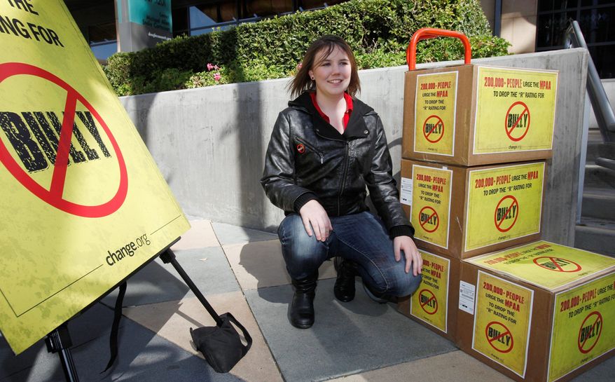 Katy Butler, 17, a high school student, from Ann Arbor, Mich., poses by the petitions she delivered to the Motion Picture Association of America, Wednesday March 7, 2012, in Los Angeles. Butler is urging the MPAA to change the "R" rating to a "PG" for the "Bully" film. With her petition, Butler said that she was speaking out for all students who suffer every day from bullying. (AP Photo/Damian Dovarganes)