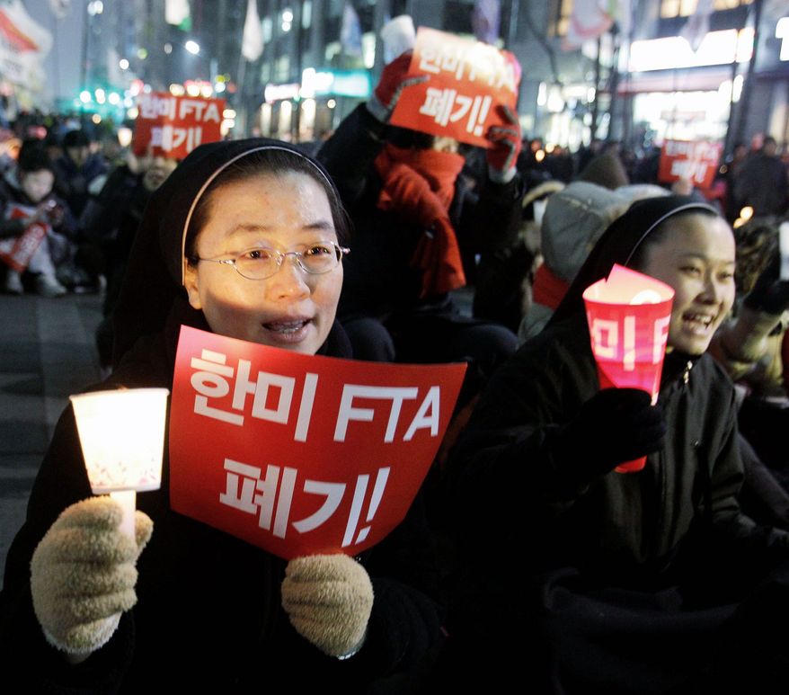 Nuns were among the protesters at a South Korean rally against the trade pact, which went into effect at midnight Wednesday. (Associated Press)