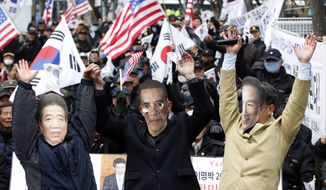 South Korean activists wearing masks of U.S. President Obama (center), South Korean President Lee Myung-bak (right) and the late South Korean President Roh Moo-hyun cheer to celebrate the free-trade agreement between South Korea and the United States during a rally near the U.S. Embassy in Seoul on Wednesday, March 14, 2012. (AP Photo/Lee Jin-man)