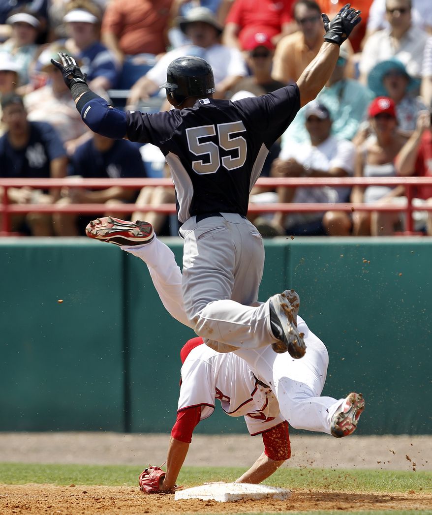 Washington Nationals starting pitcher Chien-Ming Wang trips at first base after fielding a ground ball from New York Yankees catcher Russell Martin (55) in the third inning of a spring training game in Viera, Fla., Thursday, March 15, 2012. Wang left the game after the play. (AP Photo/Paul Sancya)