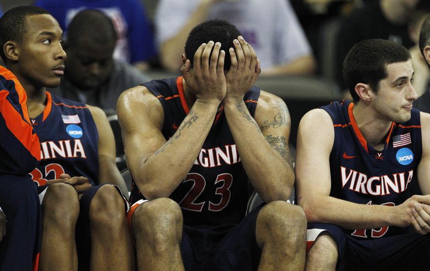 Virginia forward Mike Scott (23) holds his head while on the bench with teammates Darion Atkins (32) and Sammy Zeglinski (13) during the second half of a tournament game against Florida at CenturyLink Center in Omaha, Neb., Friday, March 16, 2012. Florida defeated Virginia 71-45. (AP Photo/Orlin Wagner)