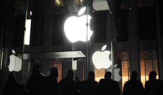 ** FILE ** People gather March 16, 2012, outside an Apple retail store on Fifth Avenue in the Manhattan borough of New York as they wait for the 8 a.m. release of the new iPad tablet. (Associated Press)