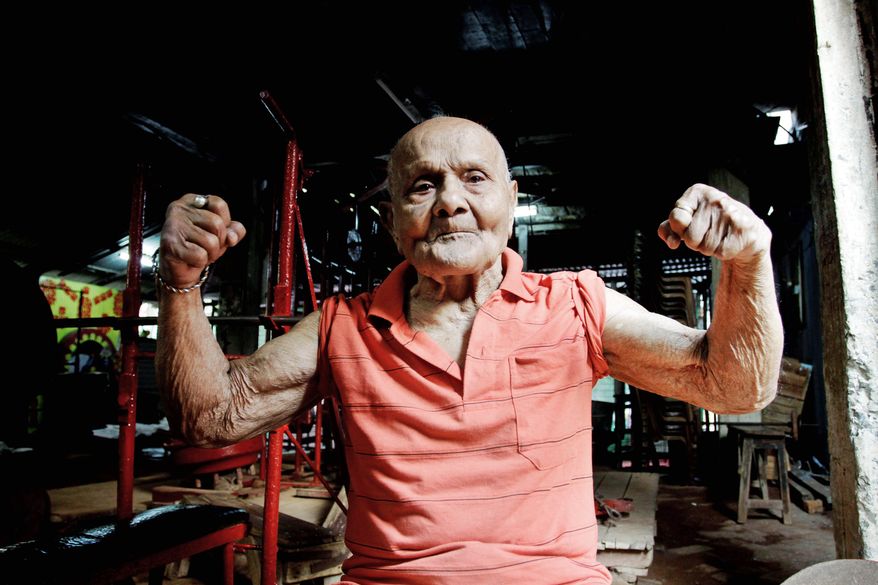 Manohar Aich flexes his muscles on Friday in a gymnasium in Kolkata. Mr. Aich, who is 4 feet 11 inches tall, won the Mr. Universe title in London in 1952. Happiness and a life without tensions are the key to his longevity, said Mr. Aich, who turned 100 on Saturday. (Associated Press)