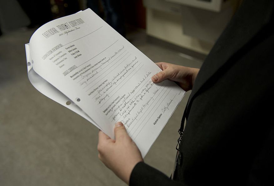 After competing in the 20th annual National Trumpet Competition, Forrest Johnson checks out the judges' notes about his performance. (Barbara L. Salisbury/The Washington Times)