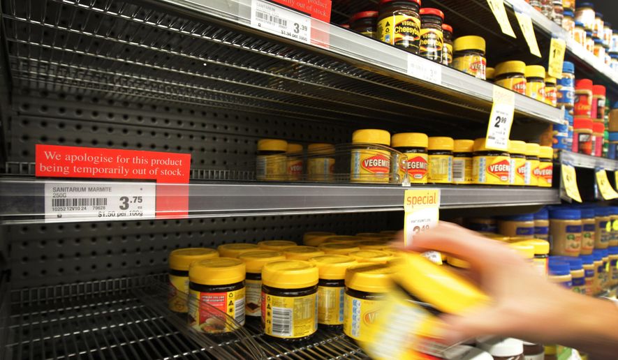 A customer takes a jar of Vegemite from the shelf next to an empty section where Marmite should be stocked in a supermarket in Auckland, New Zealand, on Tuesday, March 20, 2012. (AP Photo/New Zealand Herald, Sarah Ivey) ** FILE **