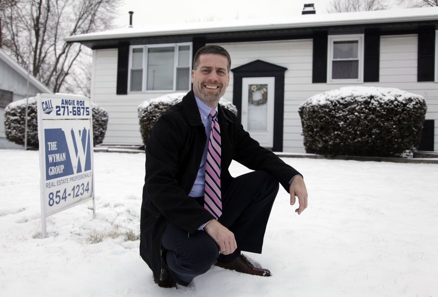 ** FILE ** In this Feb. 14, 2012, photo, Paul Wyman, a realtor and Republican County Commissioner, poses outside a foreclosed home for sale in Kokomo, Ind. (AP Photo/Michael Conroy)