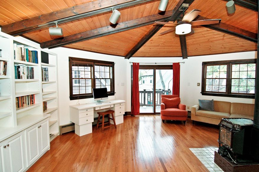 The family room has a wood ceiling with exposed beams, a ceiling fan, built-in cabinets and bookcases, and a wood stove.