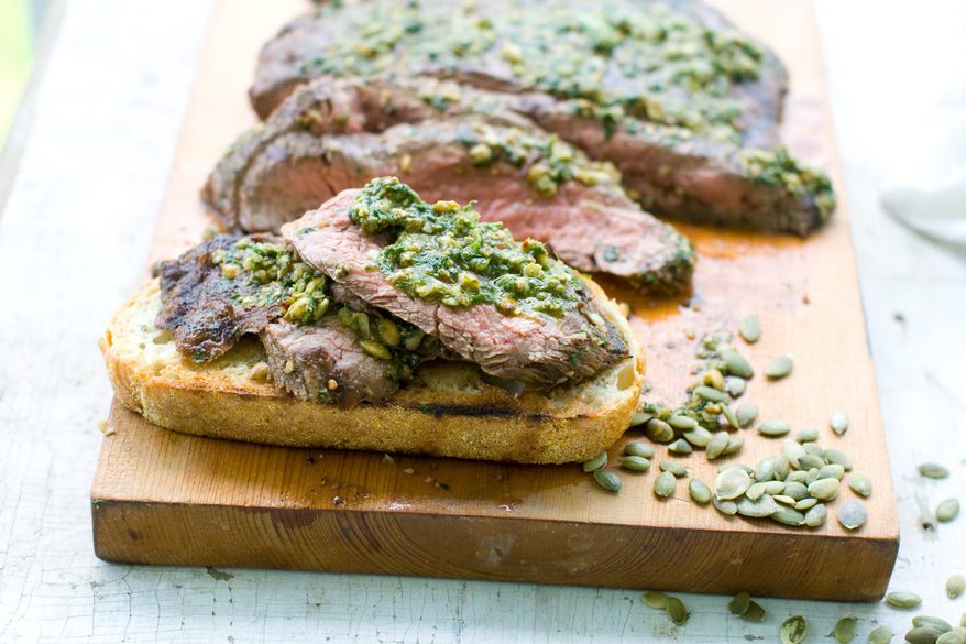 Thinly sliced marinated flank steak gets extra flavor from a sauce made with oil, vinegar, herbs and hulled, toasted pumpkin seeds, known as pepitas. The steak and sauce are served on toasted sourdough bread. (Associated Press)
